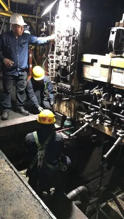 Técnicos desmontando maquinaria pesada en fosa de cimentación