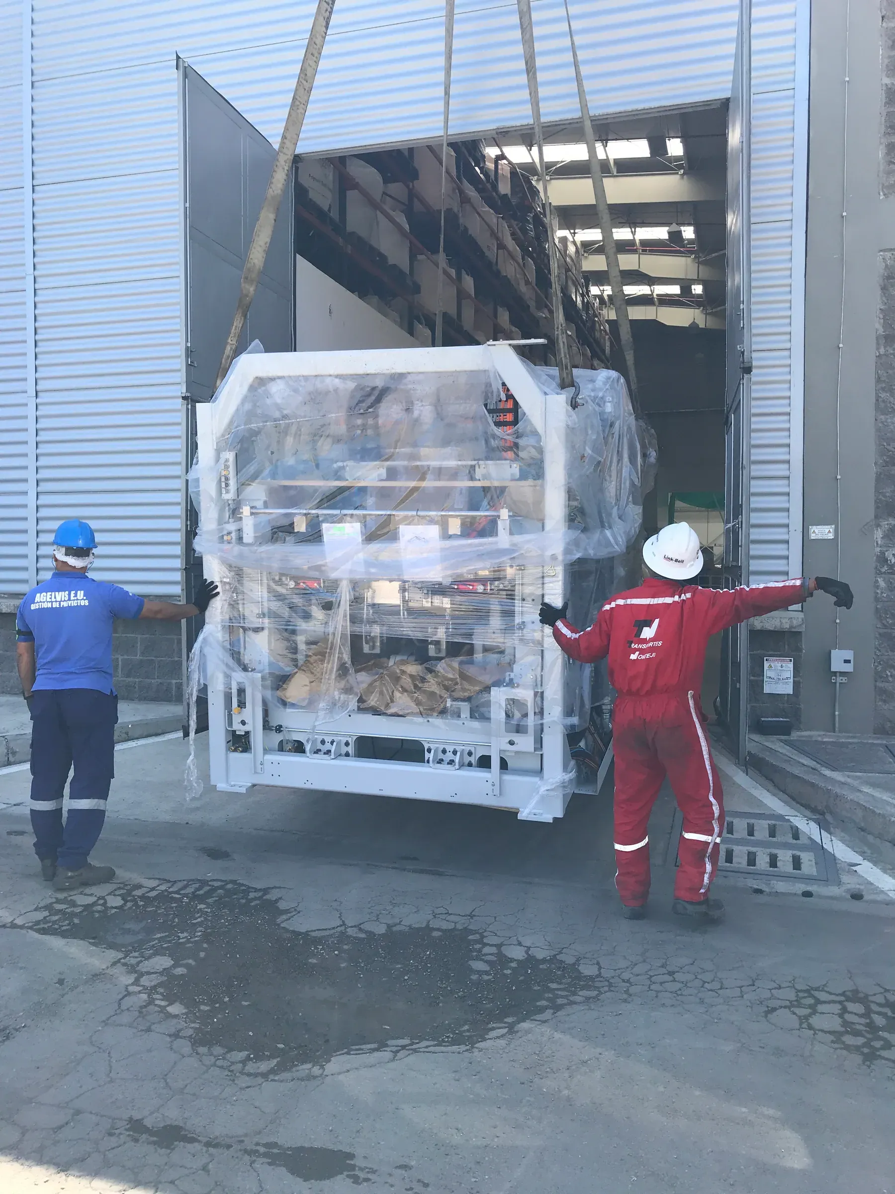 Ingreso de máquina industrial embalada a la planta del cliente con grúa