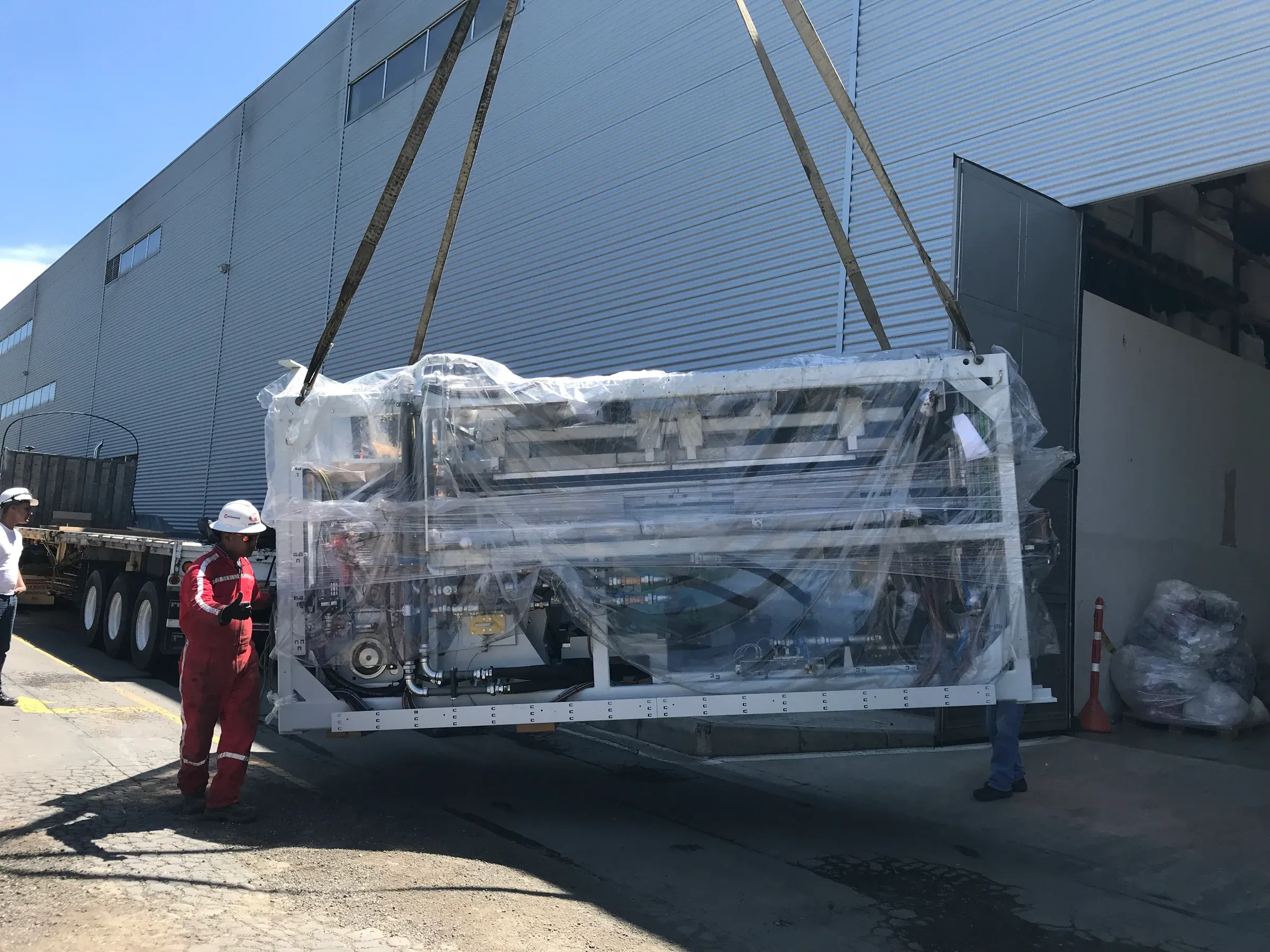 Izaje de máquina embalada hacia el interior de una nave industrial