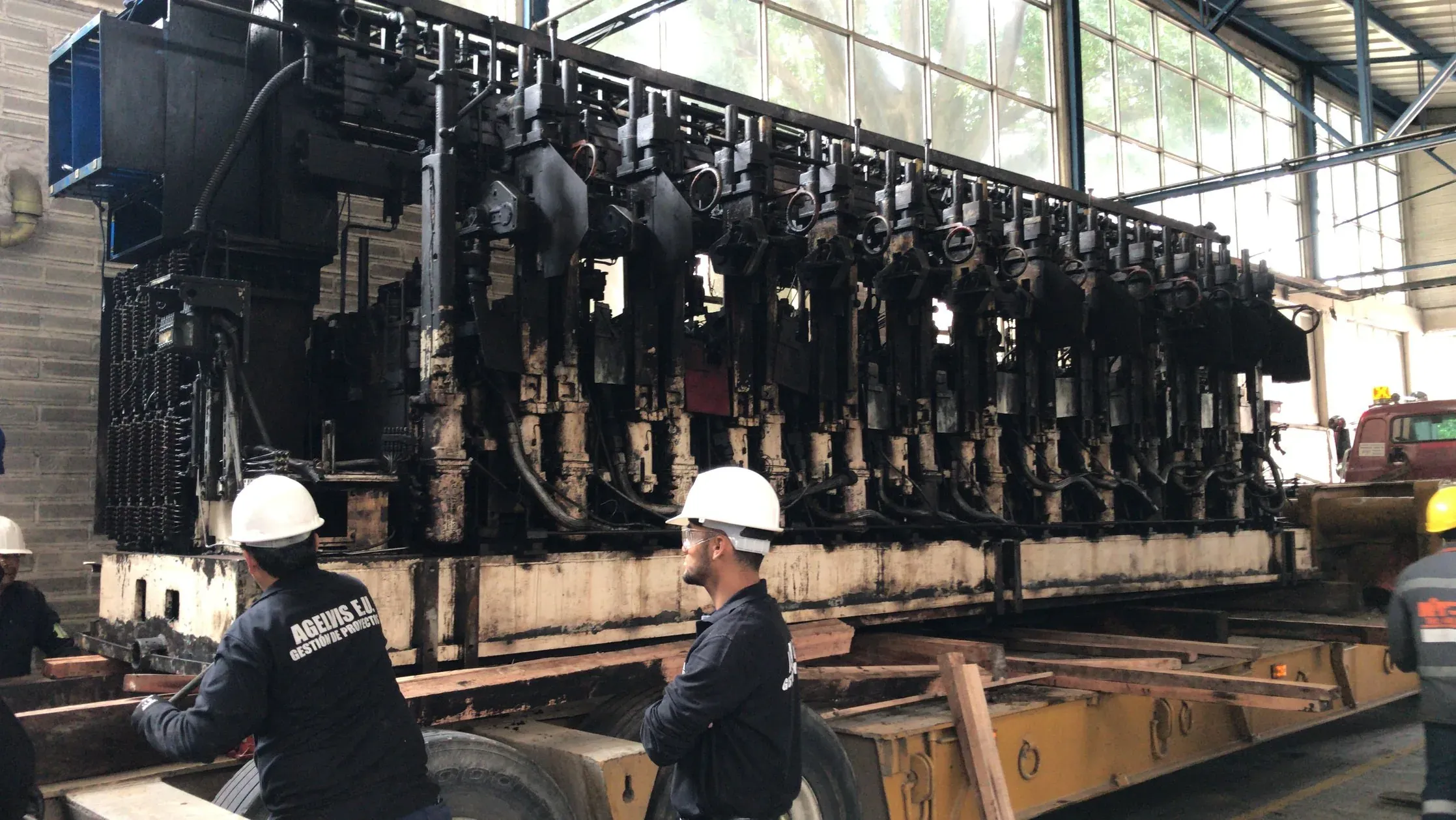Técnicos trabajando junto a una línea de maquinaria pesada durante una relocalización