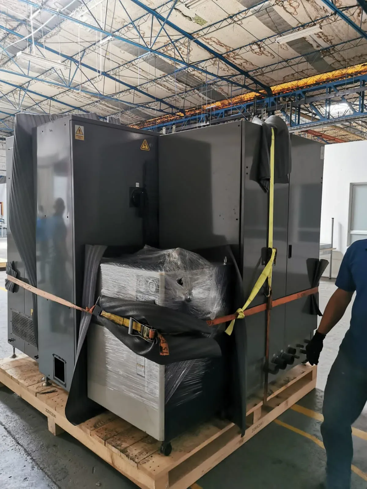 Equipo de AGELVIS EU asegurando una máquina sobre estiba en planta